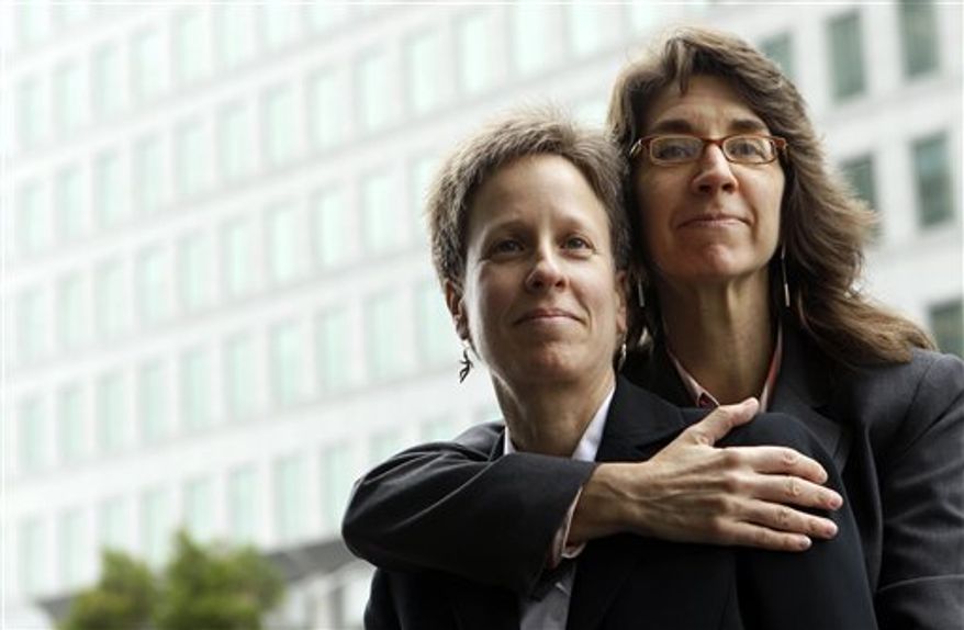 FILE - This Dec. 17, 2010 file photo shows Karen Golinski, right, hugging her wife Amy Cunninghis as they pose for a photograph outside of a federal court building in San Francisco. The fight over gay marriage is shifting from the ballot box to the Supreme Court. Three weeks after voters in three states backed it, the justices meet Friday to decide whether they should deal sooner rather than later with the idea that the Constitution gives people the right to marry regardless of a couple's sexual orientation. (AP Photo/Jeff Chiu, File)