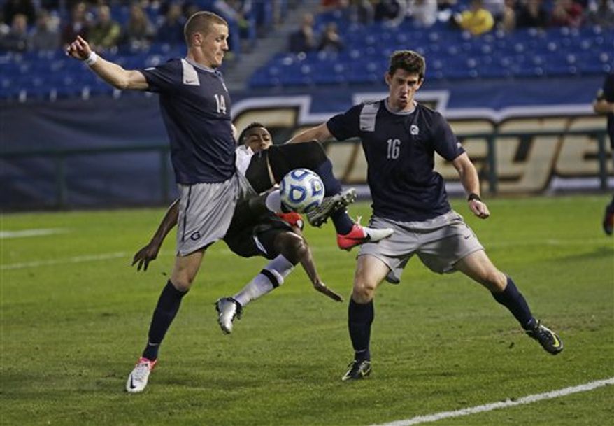 Maryland's Mikias Eticha, center, tries to shoot the ball between the defense of Georgetown's Cole Seiler, left, and Jimmy Nealis, right, in the second half of their NCAA College Cup men's championship semifinal soccer match at Regions Park, Friday, Dec. 7, 2012, in Hoover, Ala. Georgetown won in penalty kicks. (AP Photo/Dave Martin) ** FILE **