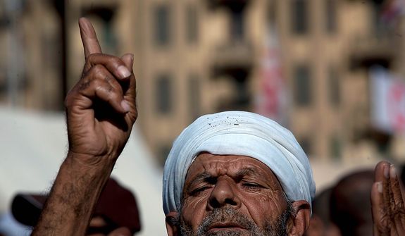 An Egyptian protester opposing president Mohammed Morsi attends Friday prayers at Tahrir Square, Cairo, Egypt, Friday, Dec. 7, 2012. Thousands of Egyptians took to the streets after Friday midday prayers in rival rallies and marches across Cairo, as the standoff deepened over what opponents call the Islamist president&#39;s power grab, raising the specter of more violence. (AP Photo/Nasser Nasser)