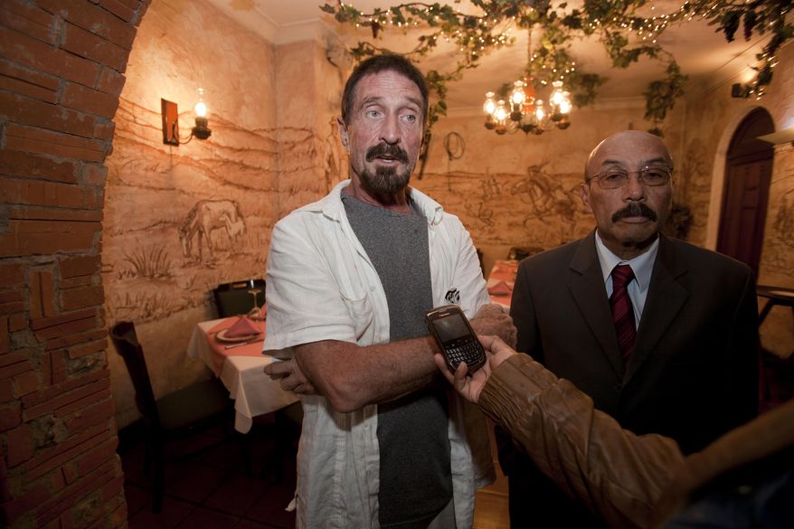 **FILE** Software company founder John McAfee (left) accompanied by his lawyer, Telesforo Guerra, answers questions during an interview at a local restaurant in Guatemala City on Dec. 4, 2012. McAfee, 67, has been identified as a "person of interest" in the killing of his neighbor in Belize, 52-year-old Gregory Faull. The anti-virus company founder fled Belize and is seeking political asylum in Guatemala, according to his lawyer. (Associated Press)