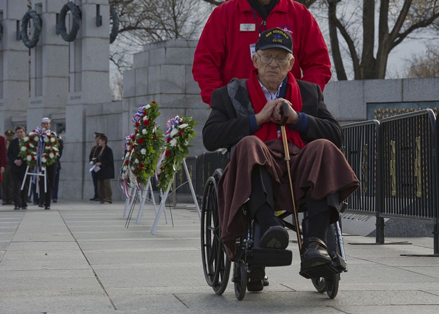 Jim Hardwick of Dallas, Texas is wheeled away after laying a wreath at the National World War II Memorial in Washington, D.C. on Friday, Dec. 7, 2012 during the National Pearl Harbor Remembrance Day ceremony. Mr. Hardwick, who was 17 when he enlisted in the U.S. Navy, served in the Pacific in World War II. (Barbara L. Salisbury/The Washington Times)