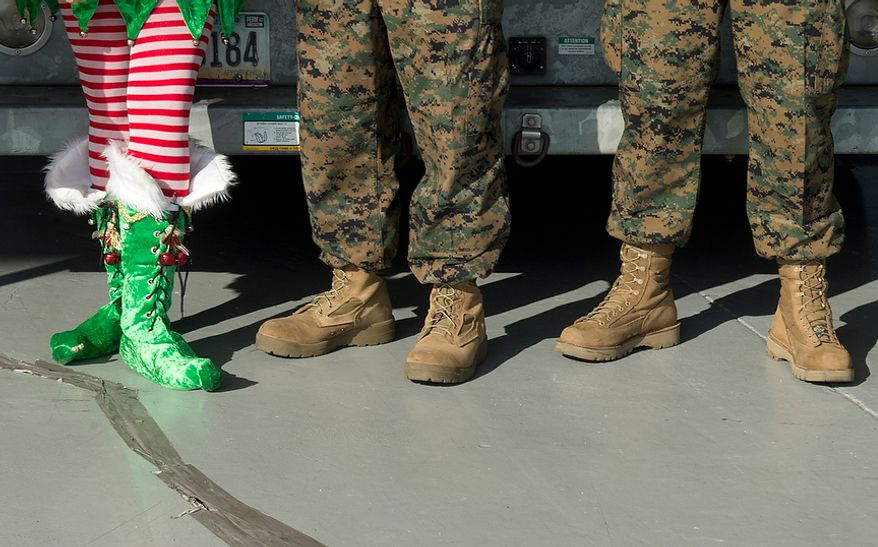 An elf stands next to Marines while waiting to load toys on the Blue Angels "Fat Albert" plane at the Signature Flight Support Terminal at Ronald Reagan National Airport on Monday, Dec. 3, 2012. Toys for Tots is taking thousands of toys on the Blue Angels plane up to New Jersey to be distributed to families in six states affected by Hurricane Sandy. (Barbara L. Salisbury/The Washington Times)