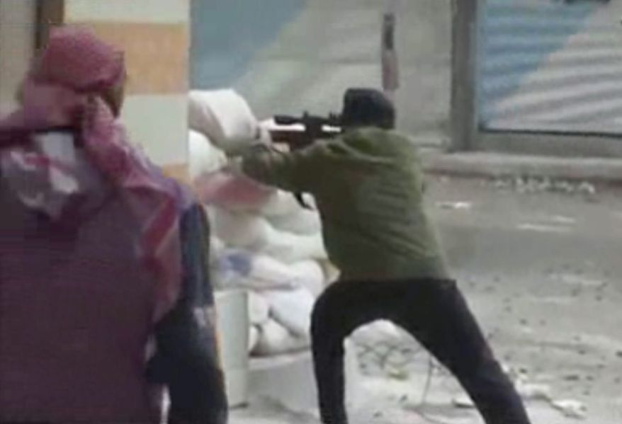 This image from amateur video that AP obtained from Ugarit News has been authenticated based on its contents and other AP reporting and shows a rebel firing a weapon around a corner at Syrian government forces in Damascus, Syria, on Dec. 7, 2012. Fighting around the Syrian capital intensified as rebels press a battle they hope will lead to the collapse of President Bashar Assad's regime after 20 months of conflict. (Associated Press/Ugarit News via AP Video)