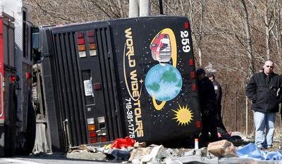 **FILE** Emergency personnel investigate the scene of a bus crash on Interstate 95 in the Bronx borough of New York on March 12, 2011. The bus driver, Ophadell Williams, who was charged in the crash that killed 15 passengers, said a tractor-trailer cut him off and he lost control. The bus carrying gamblers coming from a Connecticut casino was sheared open like a sardine can when it struck a pole. (Associated Press)