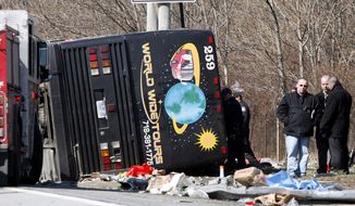 **FILE** Emergency personnel investigate the scene of a bus crash on Interstate 95 in the Bronx borough of New York on March 12, 2011. The bus driver, Ophadell Williams, who was charged in the crash that killed 15 passengers, said a tractor-trailer cut him off and he lost control. The bus carrying gamblers coming from a Connecticut casino was sheared open like a sardine can when it struck a pole. (Associated Press)