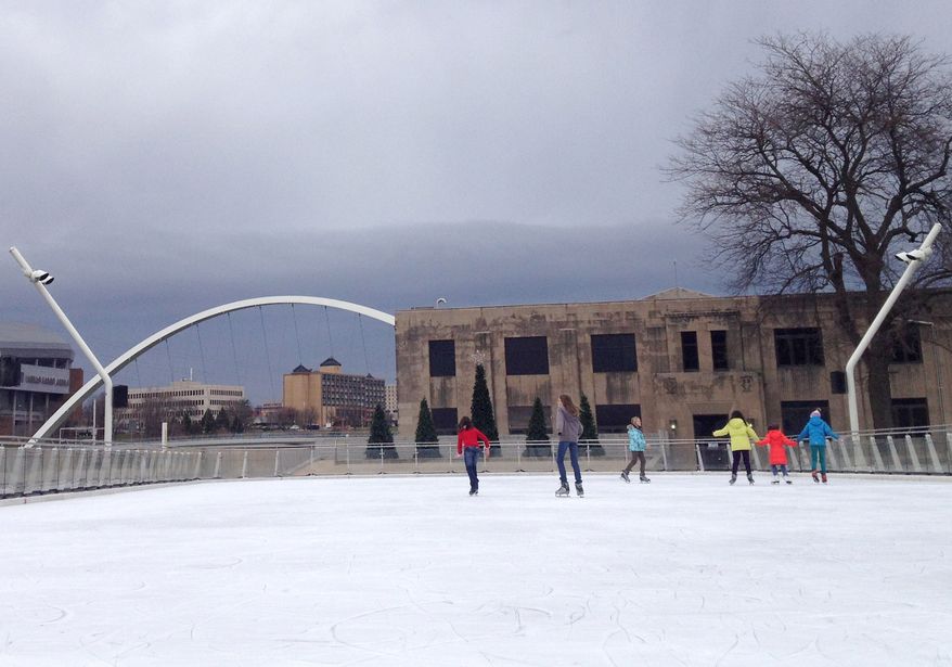 Skaters make their way across ice lightly covered with snow at Brenton Skating Plaza in downtown Des Moines, Iowa, on Dec. 6, 2012. (Associated Press
