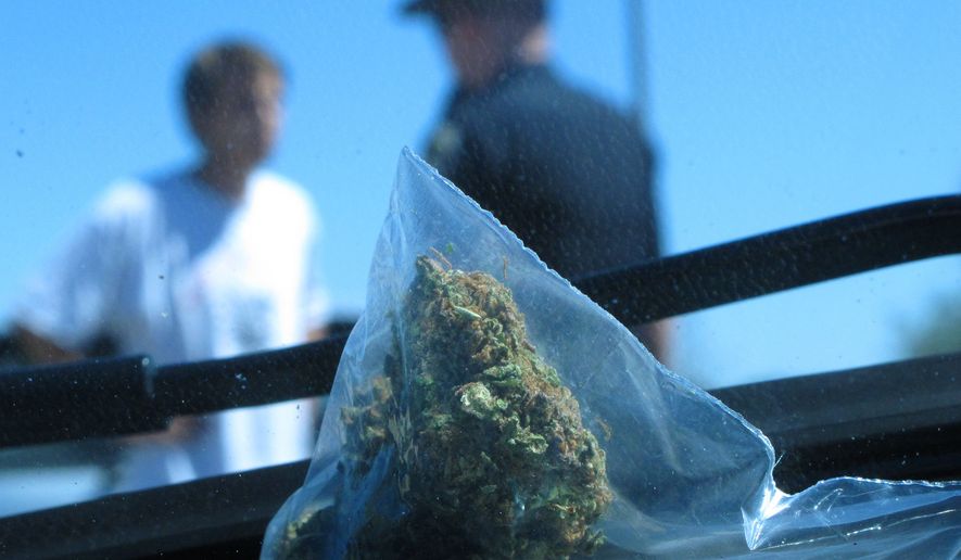 In this photo taken Wednesday June 20, 2012, David Kosmecki, left, talks to Idaho State Police Trooper Justin Klitch in Fruitland, Idaho. Kosmecki was stopped and charged with possession of marijuana after leaving Oregon. (AP Photo/Nigel Duara)