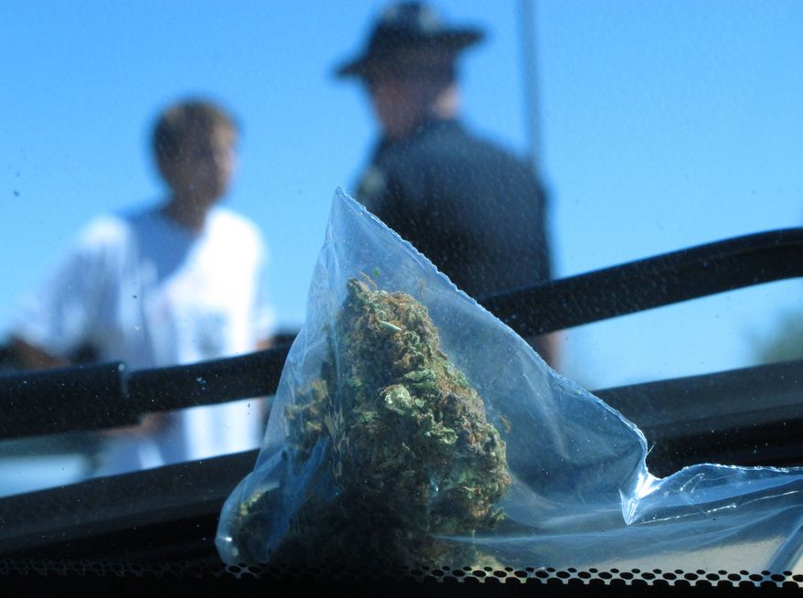 In this photo taken Wednesday June 20, 2012, David Kosmecki, left, talks to Idaho State Police Trooper Justin Klitch in Fruitland, Idaho. Kosmecki was stopped and charged with possession of marijuana after leaving Oregon. (AP Photo/Nigel Duara)