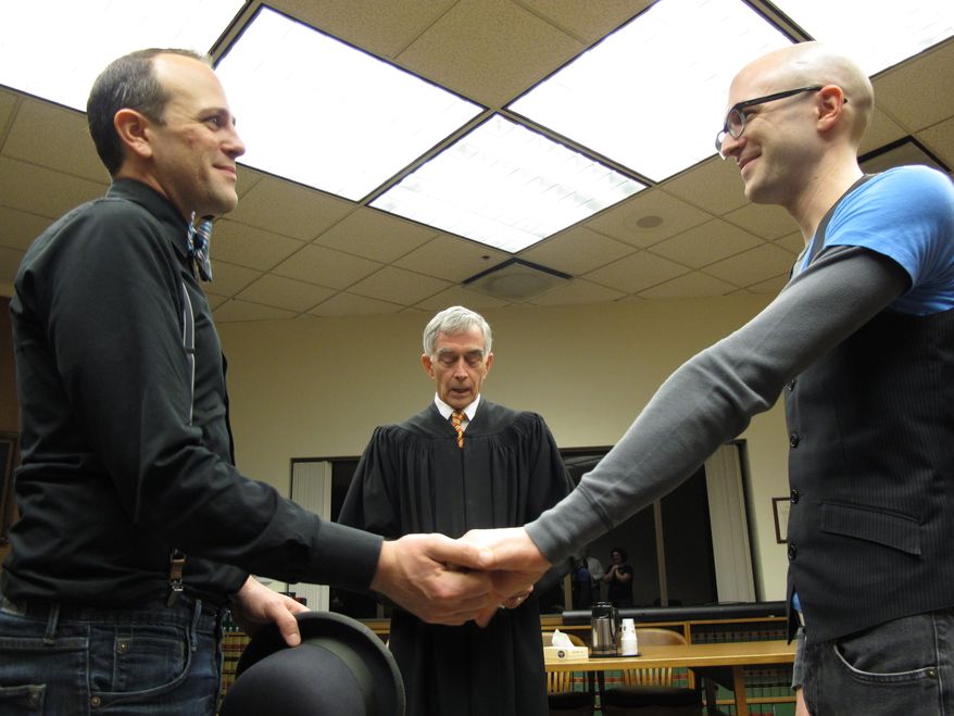 Matthew Wiltse (right) and Jonathon Bashford (left) are married by Thurston County Superior Court Judge Chris Wickham at the Thurston County Courthouse just after midnight on Sunday, Dec. 9, 2012, in Olympia, Wash. Sunday is the first day that same-sex couples can marry under Washington state's new voter-approved law allowing gay marriage. (AP Photo/Rachel La Corte)