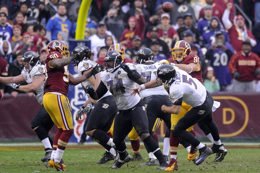 Washington Redskins outside linebacker Ryan Kerrigan (91) hits Baltimore Ravens quarterback Joe Flacco (5) forcing an interception in the third quarter at FedEx Field, Landover, Md., Dec. 9, 2012. (Preston Keres/Special to The Washington Times)