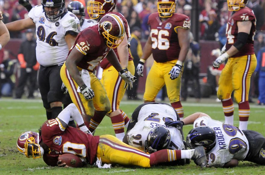 Washington Redskins quarterback Robert Griffin III (10) lies on the ground after being sacked deep in Redskins territory in the fourth quarter at FedEx Field, Landover, Md., Dec. 9, 2012. (Preston Keres/Special to The Washington Times)