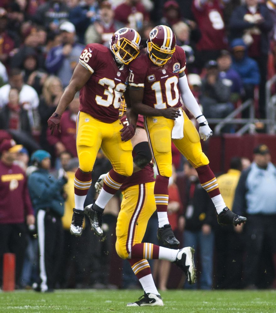 Washington Redskins quarterback Robert Griffin III (10) celebrates with fullback Darrel Young (36) after scoring a touchdown in the first half against the Baltimore Ravens at FedEx Field in Landover Md., on Sunday, December 9, 2012. (Craig Bisacre/The Washington Times)