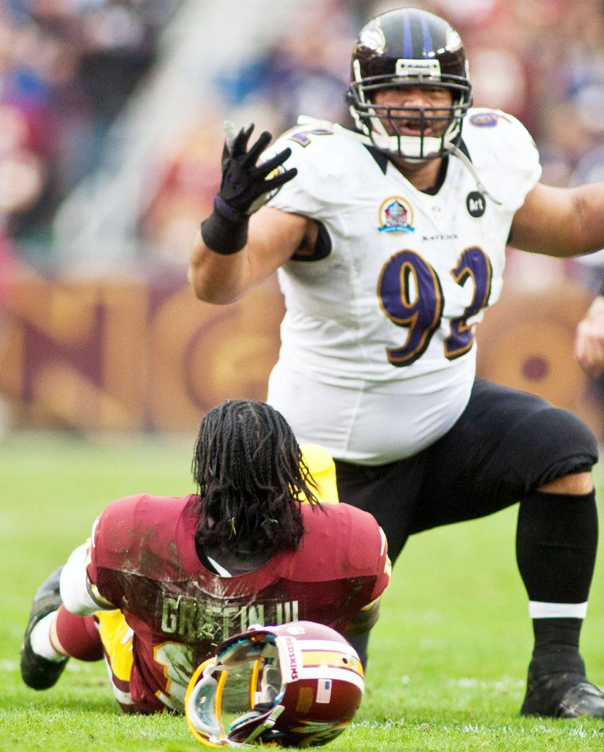 Washington Redskins quarterback Robert Griffin III (10) is lays on the ground after getting hit hard by Baltimore Ravens defensive end Haloti Ngata (92) in the first half at FedEx Field in Landover Md., on Sunday, December 9, 2012. (Craig Bisacre/The Washington Times)