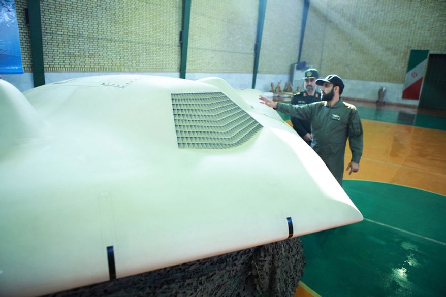 This photo released Dec. 8, 2011, by the Iranian Revolutionary Guards claims to show a U.S. RQ-170 Sentinel drone that Tehran said its forces downed earlier in the week, as an unidentified colonel talks to Gen. Amir Ali Hajizadeh (left), chief of the aerospace division of Iran's Revolutionary Guards, in an undisclosed location in Iran. (Associated Press/Sepahnews)