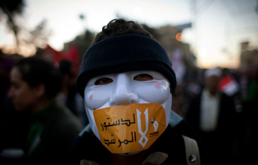 An Egyptian protester with a mask on his face and a sticker with Arabic that reads "No for the constitution of the Morshid" during a protest against President Mohammed Morsi near the presidential palace in Cairo on Dec. 7, 2012. (Associated Press)
