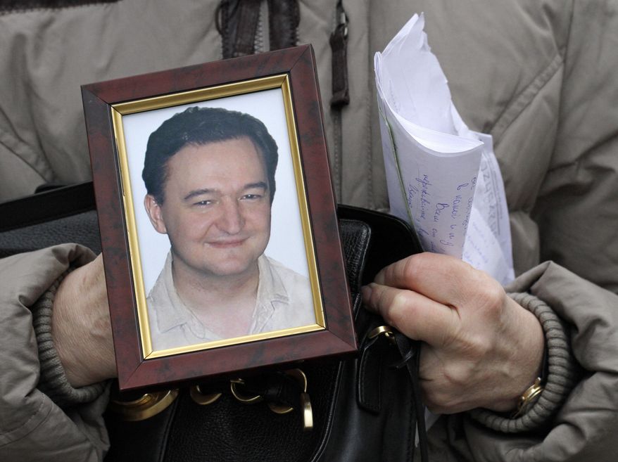 Nataliya Magnitskaya, mother of Russian lawyer Sergei Magnitsky, who died in jail, holds his portrait during an interview with the AP in Moscow in 2009. (AP Photo/Alexander Zemlianichenko)