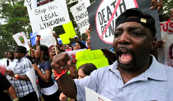 **FILE** Demonstrators chant slogans against the death penalty at a Sept. 21, 2011, rally in Jackson, Ga., for Georgia death row inmate Troy Davis, who was executed later that day for the 1991 murder of a police officer. (Associated Press)