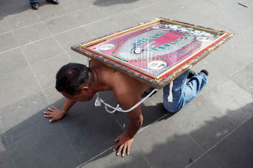 A man crawls carrying an image of the Virgin of Guadalupe on his back as he approaches the entrance to the Basilica of Guadalupe in Mexico City, Tuesday, Dec. 11, 2012. Nationwide, devotees of the Virgin of Guadalupe make a pilgrimage to the Basilica in honor of her Dec. 12 feast day. (AP Photo/Eduardo Verdugo)