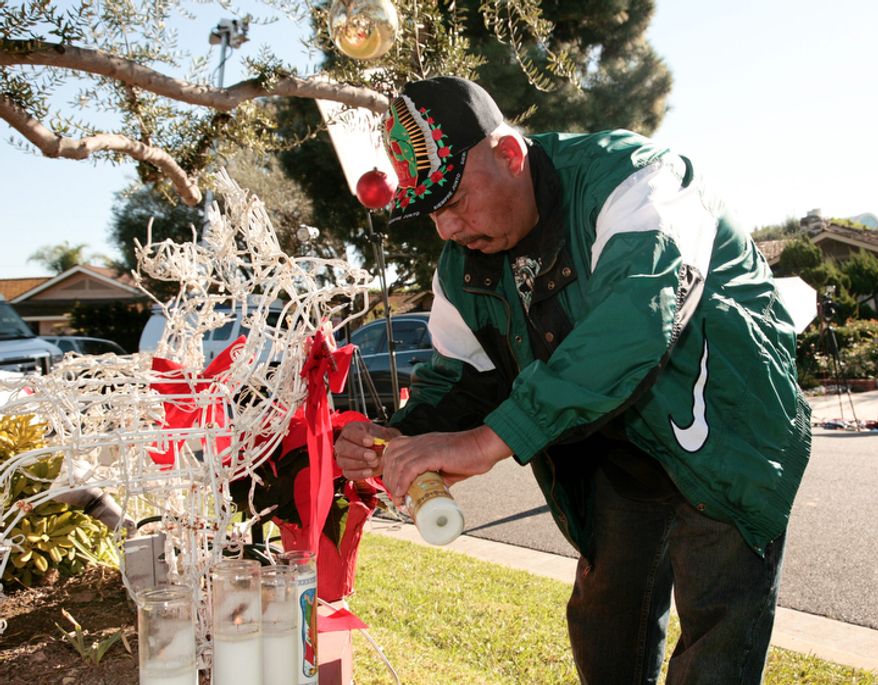 Fan Jose Ruelas lights a candle outside the home of singer Jenni Rivera's mother in Lakewood, Calif., on Dec. 10, 2012. Rivera died the previous day in a plane crash in Mexico. (Associated Press)