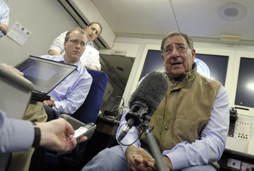 Defense Secretary Leon E. Panetta (right) talks to reporters on board his plane while headed to Kuwait on Monday, Dec. 10, 2012. Mr. Panetta will meet with U.S. troops as part of a visit to thank them for their service. (AP Photo/Susan Walsh, Pool)