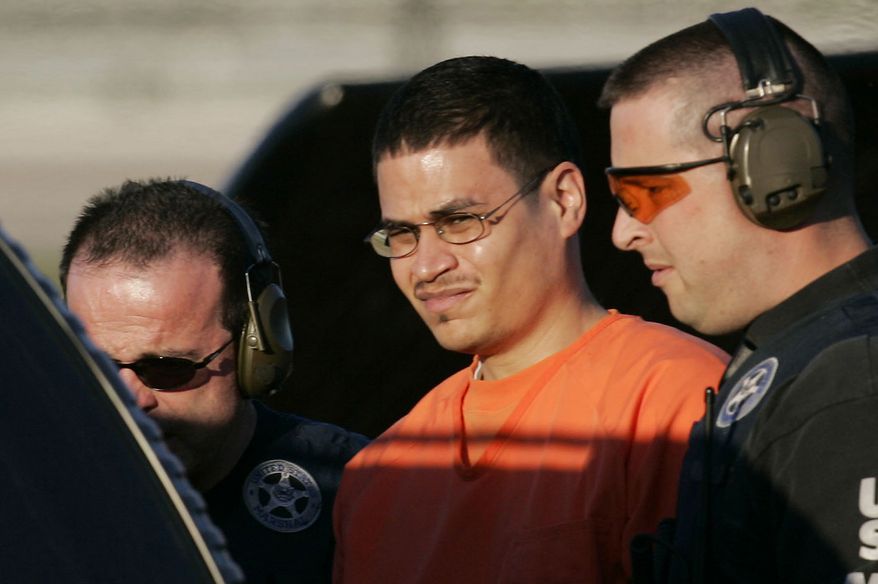 **FILE** Convicted terrorism plotter Jose Padilla (center) is escorted to a waiting police vehicle by federal marshals near downtown Miami on Jan. 5, 2006. (Associated Press)