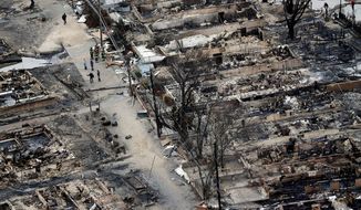 ** FILE ** An aerial view shows burned-out homes in the Breezy Point section of the Queens borough of New York on Tuesday, Oct. 30, 2012. The tiny beachfront neighborhood, told to evacuate before Superstorm Sandy hit New York, burned down as it was inundated by floodwaters, transforming a quaint corner of the Rockaways into a smoke-filled debris field. (AP Photo/Mike Groll)