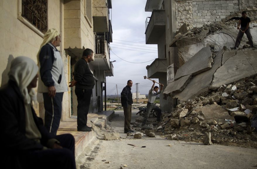 Syrian men use sledgehammers to break the concrete and search for belongings under the rubble of a residential building in Maaret Misreen, near Idlib, Syria, that was destroyed in a government airstrike on Dec. 12, 2012. (Associated Press)