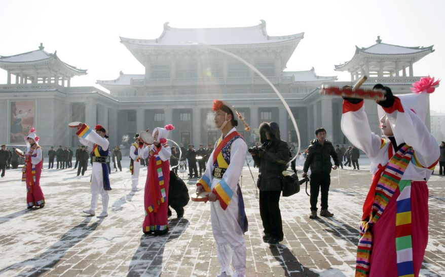 North Korean youths in traditional Korean outfit play instruments in front of the Pyongyang Grand Theatre in Pyongyang, North Korea, on Dec. 12, 2012, to celebrate a rocket launch. North Korea appeared to successfully fire a long-range rocket, defying international warnings as the regime of Kim Jong Un pushes forward with its quest to develop the technology needed to deliver a nuclear warhead. (Associated Press)