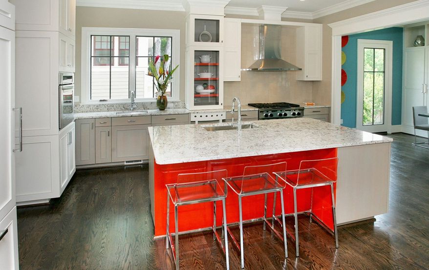 The white-on-white kitchen features a center island, granite counters, two sinks and three dishwashers.