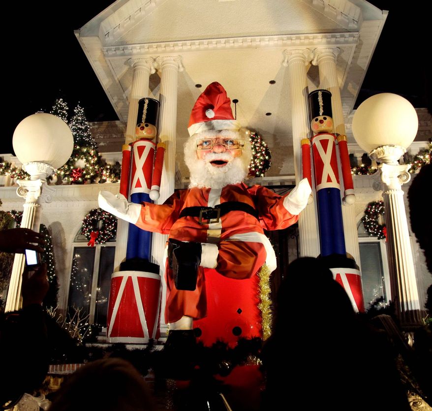 A giant Santa Claus stands amid other Christmas decorations outside a home in Brookyn, where neighbors dress up their yards and home exteriors in grand style. (Associated Press)
