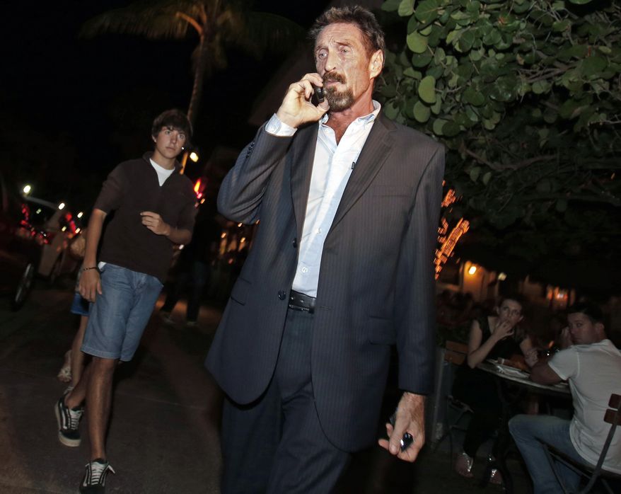 Anti-virus software founder John McAfee talks on his mobile phone as he walks on Ocean Drive in the South Beach area of Miami Beach, Fla., on his way to dinner on Wednesday, Dec 12, 2012. (AP Photo/Alan Diaz)