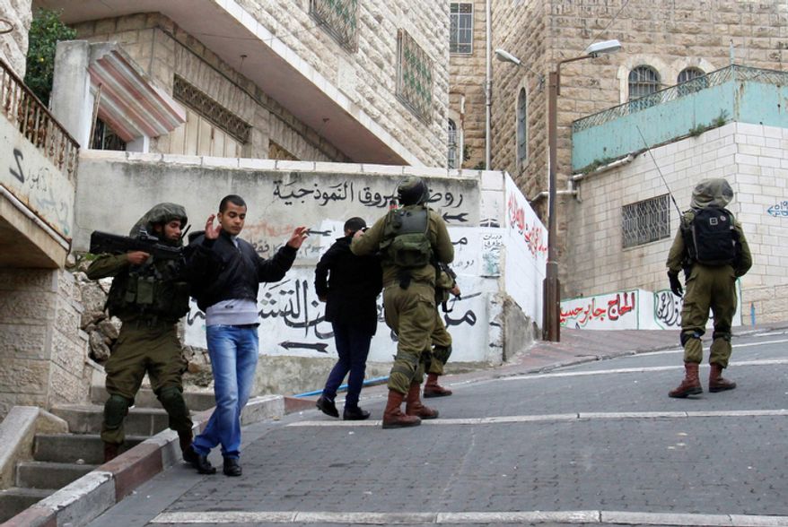 Israeli soldiers detain Palestinian youths during the funeral Mohammed Suleima, 17, in the West Bank city of Hebron, Thursday, Dec. 13, 2012. (AP Photo/Nasser Shiyoukhi)