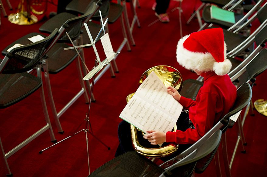 Aidan Smith, 11, of Bethesda, Md. looks over the music that he and hundreds of other tuba players will perform at the Millennium Stage at the Kennedy Center. (Barbara L. Salisbury/The Washington Times)