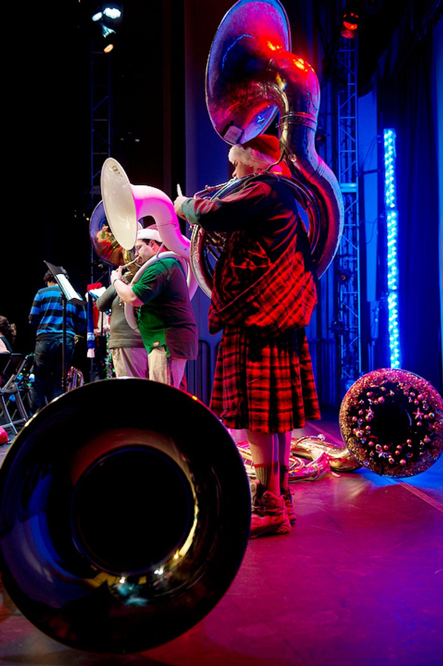 Bass tubists, including Santo Buzzanca, left, of Washington, D.C., rehearse on the Millennium Stage at the Kennedy Center in Washington, D.C. on Thursday, Dec. 13, 2012 for Tuba Christmas. More than 200 tubists participated in this year's event. (Barbara L. Salisbury/The Washington Times)