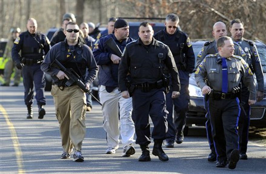 Law enforcement canvass the area following a shooting at the Sandy Hook Elementary School in Newtown, Conn., about 60 miles (96 kilometers) northeast of New York City, Friday, Dec. 14, 2012. An official with knowledge of Friday's shooting said 27 people were dead, including 18 children. (AP Photo/Jessica Hill)
