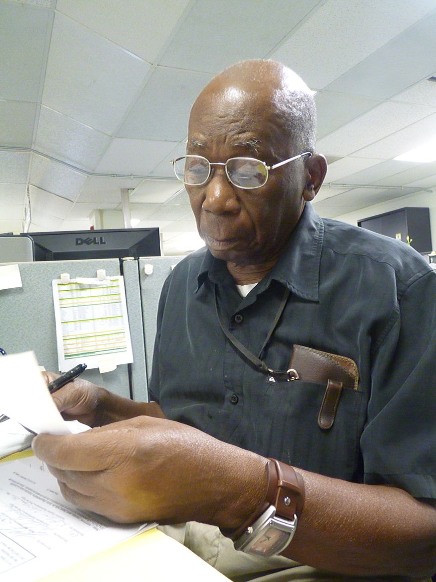Harry Henry spends one of his last days working going over paperwork on the U.S. Naval Station base in Guantanamo Bay, Cuba, on Dec. 13, 2012. Henry travels from home in the Cuban city of Guantanamo to his job on the U.S. Navy base at the southeastern edge of his country, a journey that takes less than an hour but spans two worlds. (Associated Press)