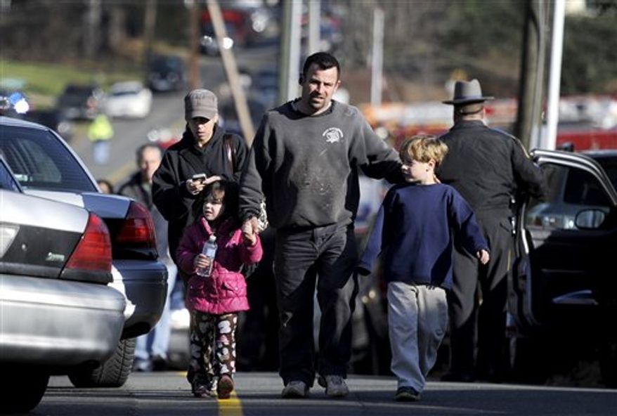 Parents leave a staging area after being reunited with their children following the shooting at the Sandy Hook Elementary School in Newtown, Conn., about 60 miles northeast of New York, on Friday, Dec. 14, 2012. Twenty schoolchildren and six staff members died in the rampage. (AP Photo/Jessica Hill)