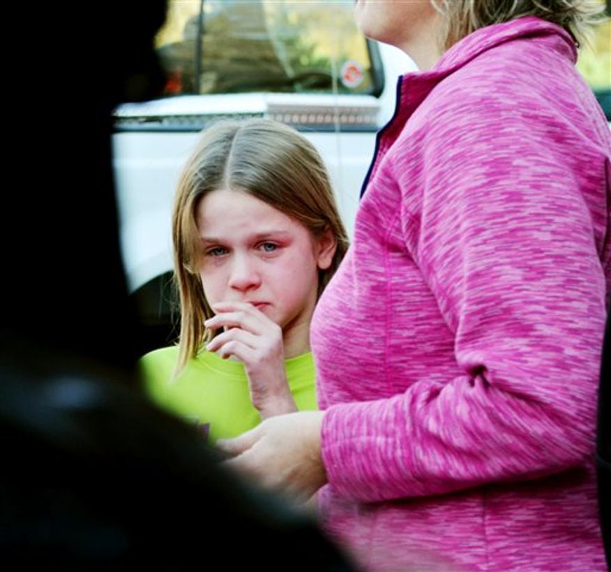 A young girl cires following a shooting at the Sandy Hook Elementary School in Newtown, Conn., about 60 miles (96 kilometers) northeast of New York City, Friday, Dec. 14, 2012. An official with knowledge of Friday's shooting said 27 people were dead, including 18 children. (AP Photo/The New Haven Register, Melanie Stengel)