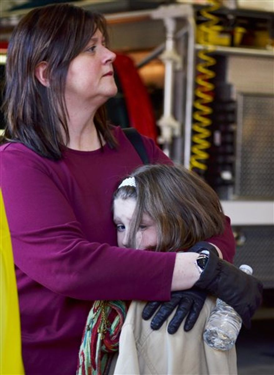 A mother hugs her daughter following a shooting at the Sandy Hook Elementary School in Newtown, Conn., about 60 miles (96 kilometers) northeast of New York City, Friday, Dec. 14, 2012. An official with knowledge of Friday's shooting said 27 people were dead, including 18 children. It was the worst school shooting in the country's history. (AP Photo/The New Haven Register, Melanie Stengel)