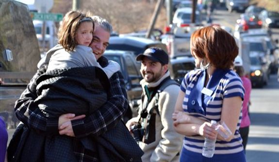 A young girl is comforted following a shooting at the Sandy Hook Elementary School in Newtown, Conn., about 60 miles (96 kilometers) northeast of New York City, Friday, Dec. 14, 2012. An official with knowledge of Friday&#39;s shooting said 27 people were dead, including 18 children. It was the worst school shooting in the country&#39;s history. (AP Photo/The New Haven Register, Melanie Stengel)  