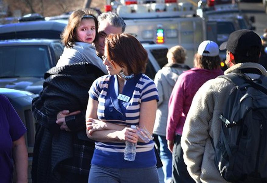 A young girl is comforted following a shooting at the Sandy Hook Elementary School in Newtown, Conn., about 60 miles (96 kilometers) northeast of New York City, Friday, Dec. 14, 2012. An official with knowledge of Friday's shooting said 27 people were dead, including 18 children. It was the worst school shooting in the country's history. (AP Photo/The New Haven Register, Melanie Stengel)