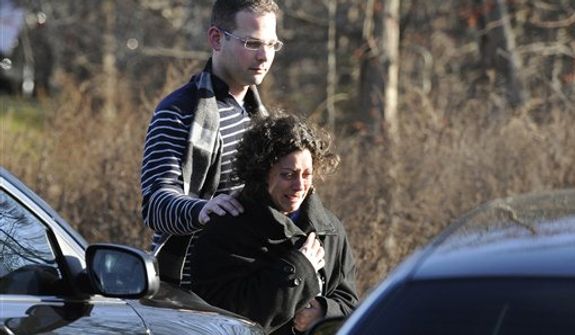A man and woman leave the staging area for family around near the scene of a shooting at the Sandy Hook Elementary School in Newtown, Conn., about 60 miles (96 kilometers) northeast of New York City, Friday, Dec. 14, 2012. An official with knowledge of Friday&#39;s shooting said 27 people were dead, including 18 children.  (AP Photo/Jessica Hill)
