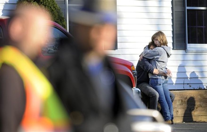 People embrace at a firehouse staging area for family around near the scene of a shooting at the Sandy Hook Elementary School in Newtown, Conn., about 60 miles (96 kilometers) northeast of New York City, Friday, Dec. 14, 2012. An official with knowledge of Friday's shooting said 27 people were dead, including 18 children. (AP Photo/Jessica Hill)
