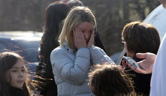 A woman weeps as she arrives to pick up her children at the Sandy Hook Elementary School, Friday, Dec. 14, 2012 in Newtown, Conn. A man opened fire inside the Connecticut elementary school where his mother worked Friday, killing 26 people, including 18 children, and forcing students to cower in classrooms and then flee with the help of teachers and police. (AP Photo/The Journal News, Frank Becerra Jr.) MANDATORY CREDIT, NYC OUT, NO SALES, TV OUT, NEWSDAY OUT; MAGS OUT