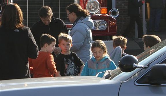 School children wait for their parents at the Sandy Hook firehouse following a mass shooting at the Sandy Hook Elementary School  Friday, Dec. 14, 2012 in Newtown, Conn. A man opened fire inside the Connecticut elementary school where his mother worked Friday, killing 26 people, including 18 children, and forcing students to cower in classrooms and then flee with the help of teachers and police. (AP Photo/The Journal News, Frank Becerra Jr.) MANDATORY CREDIT, NYC OUT, NO SALES, TV OUT, NEWSDAY OUT; MAGS OUT