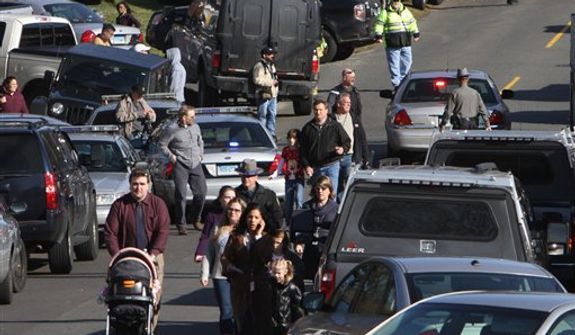 Parents walk away from the Sandy Hook School with their children following a shooting at the school Friday, Dec. 14, 2012 in Newtown, Conn. A man opened fire inside the Connecticut elementary school where his mother worked Friday, killing 26 people, including 18 children, and forcing students to cower in classrooms and then flee with the help of teachers and police. (AP Photo/The Journal News, Frank Becerra Jr.) MANDATORY CREDIT, NYC OUT, NO SALES, ONLINE OUT, TV OUT, NEWSDAY OUT; MAGS OUT
