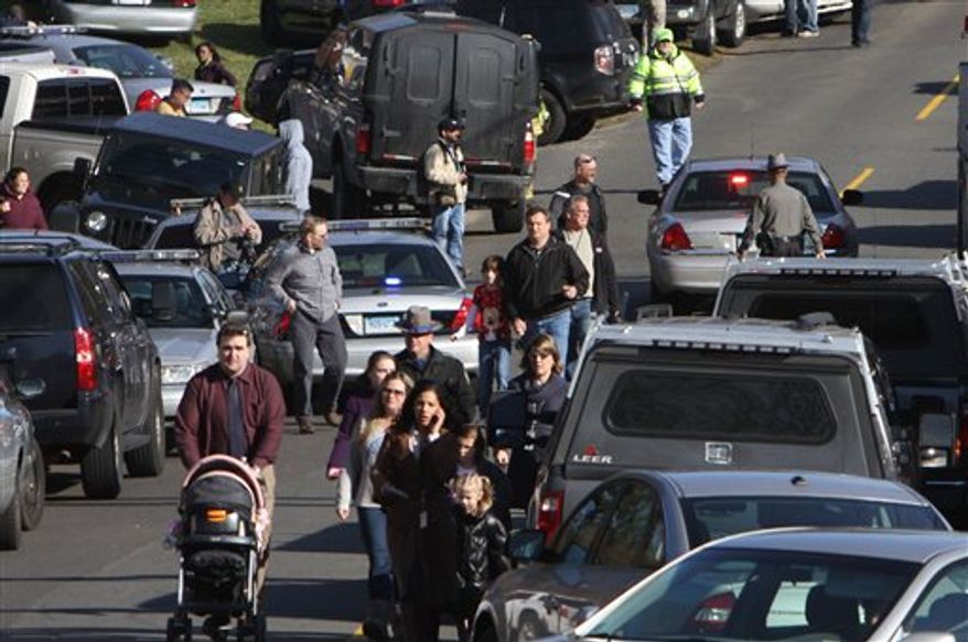Parents walk away from the Sandy Hook School with their children following a shooting at the school Friday, Dec. 14, 2012 in Newtown, Conn. A man opened fire inside the Connecticut elementary school where his mother worked Friday, killing 26 people, including 18 children, and forcing students to cower in classrooms and then flee with the help of teachers and police. (AP Photo/The Journal News, Frank Becerra Jr.) MANDATORY CREDIT, NYC OUT, NO SALES, ONLINE OUT, TV OUT, NEWSDAY OUT; MAGS OUT
