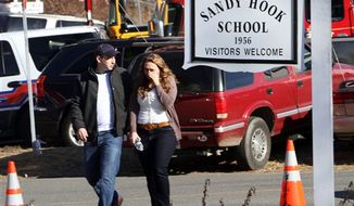 Parents walk away from the Sandy Hook Elementary School in Newtown, Conn., on Friday, Dec. 14, 2012, after a gunman killed 20 schoolchildren and 6 adults there. (AP Photo/The Journal News, Frank Becerra Jr.)