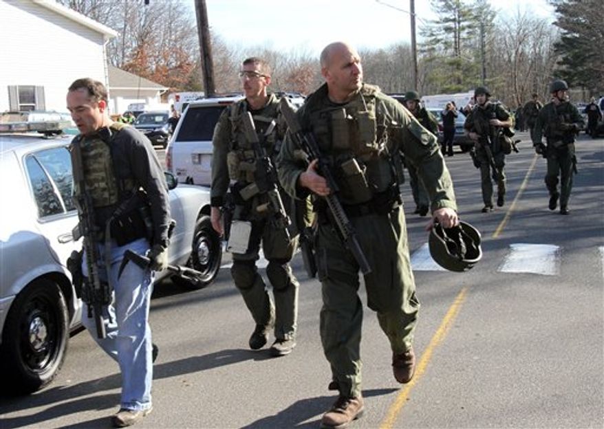 Heavily armed Connecticut State troopers are on the scene at the Sandy Hook School following a shooting at the school, Friday, Dec. 14, 2012 in Newtown, Conn. A man opened fire inside the Connecticut elementary school where his mother worked Friday, killing 26 people, including 18 children, and forcing students to cower in classrooms and then flee with the help of teachers and police. (AP Photo/The Journal News, Frank Becerra Jr.) MANDATORY CREDIT, NYC OUT, NO SALES, TV OUT, NEWSDAY OUT; MAGS OUT