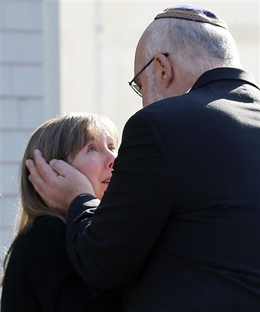 Two people embrace following a service at the Congregation Adath Israel in Newtown, Conn., Saturday, Dec. 15, 2012. Rabbi Shaul Praver said a six-year-old boy from the congregation was a school shooting victim and that he would be buried on Sunday. (AP Photo/Charles Krupa)